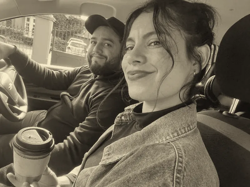 Gisella y Facundo en el auto, con un café